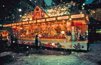 Snowflakes falling on a festively lit stall