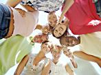 A group of young people standing in a circle photographed from the centre