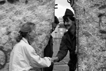 A woman and a man shaking hands at the Berlin Wall, Copyright CORBIS / Peter Tumley