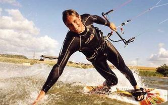 Kite surfer touching the water with his hand; Photo by Karsten Brandl