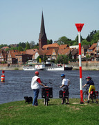 Three cyclists on the banks of the river