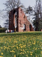 A family explore the ruins of a Brick Gothic abbey