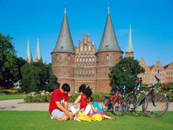 A family enjoy a picnic in front of the stunning Holsten Gate in Lübeck