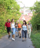 Walkers enjoy a walk up the hill with the town in the background
