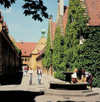 Couples stroll in one of the streets of the Fuggerei, the oldest welfare housing project in the world