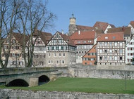 Row of historical timber-framed buildings by a bridge
