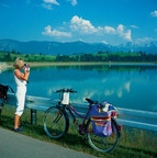 Woman with binoculars at lake Premer Lechsee with Allgäu Alps