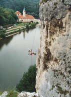 Climber abseiling with Weltenburg Abbey in the background
