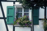 Half-timbered building with white window frames and green shutters