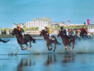 Riders galloping across the mudflats