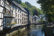 A row of half-timbered houses along a river, seen from the back