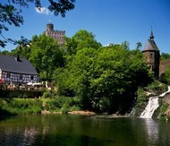 Pyrmont Castle with a small waterfall in the Eltzbach valley in the Eifel