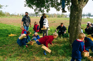 Children and adults collecting apples in an orchard