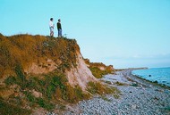 Two walkers look out across the Baltic Sea