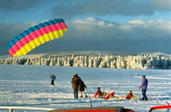 Paraglider landing on the snow-covered Mount Wasserkuppe
