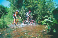 Two cyclists crossing a stream in the Sauerland region