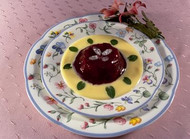Plate of red fruit compote with vanilla sauce