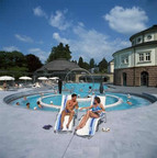 Man and woman on deck chairs in the outdoor area of thermal baths