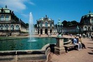 Inner courtyard of the Zwinger palace with tourists sitting by the fountain